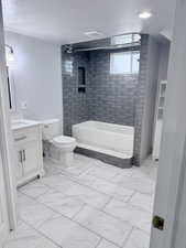 Full bathroom featuring vanity, light marble finish floors, and shower / bathtub combination