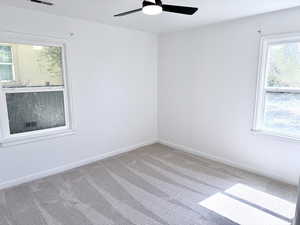 Unfurnished room featuring light colored carpet and ceiling fan