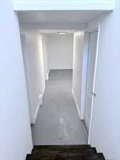 Hallway featuring concrete floors and baseboards