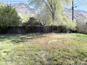 Fenced backyard featuring a mountain view