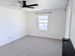 Spare room featuring light carpet and a ceiling fan
