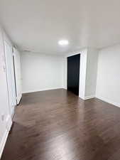 Unfurnished room featuring dark wood-style floors and baseboards