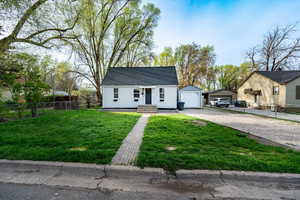 View of front of property with a garage, driveway, and a shingled roof
