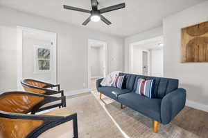 Living area with light wood finished floors and ceiling fan