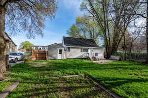 Back of property with a fenced backyard, entry steps, and a gate