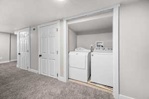 Laundry area with light carpet and washer and dryer