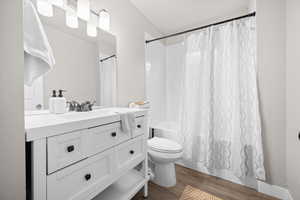 Bathroom with vanity, dark wood-style flooring, and shower / bath combo
