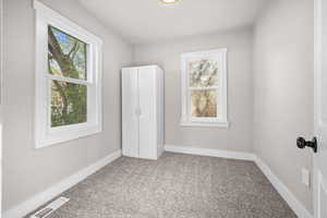 Unfurnished bedroom with light colored carpet and baseboards