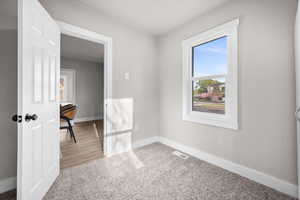 Unfurnished room with baseboards and light colored carpet