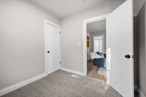 Unfurnished bedroom with baseboards and light colored carpet