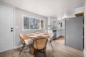 Dining area featuring light wood-type flooring and a textured ceiling