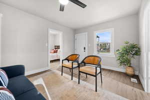 Sitting room with light wood-style floors and a ceiling fan