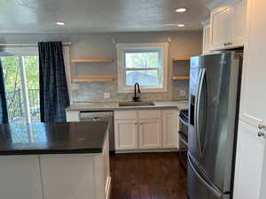 Kitchen featuring open shelves, white cabinets, stainless steel appliances, recessed lighting, and dark wood finished floors