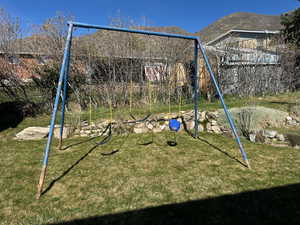 View of play area with a yard and a mountain view