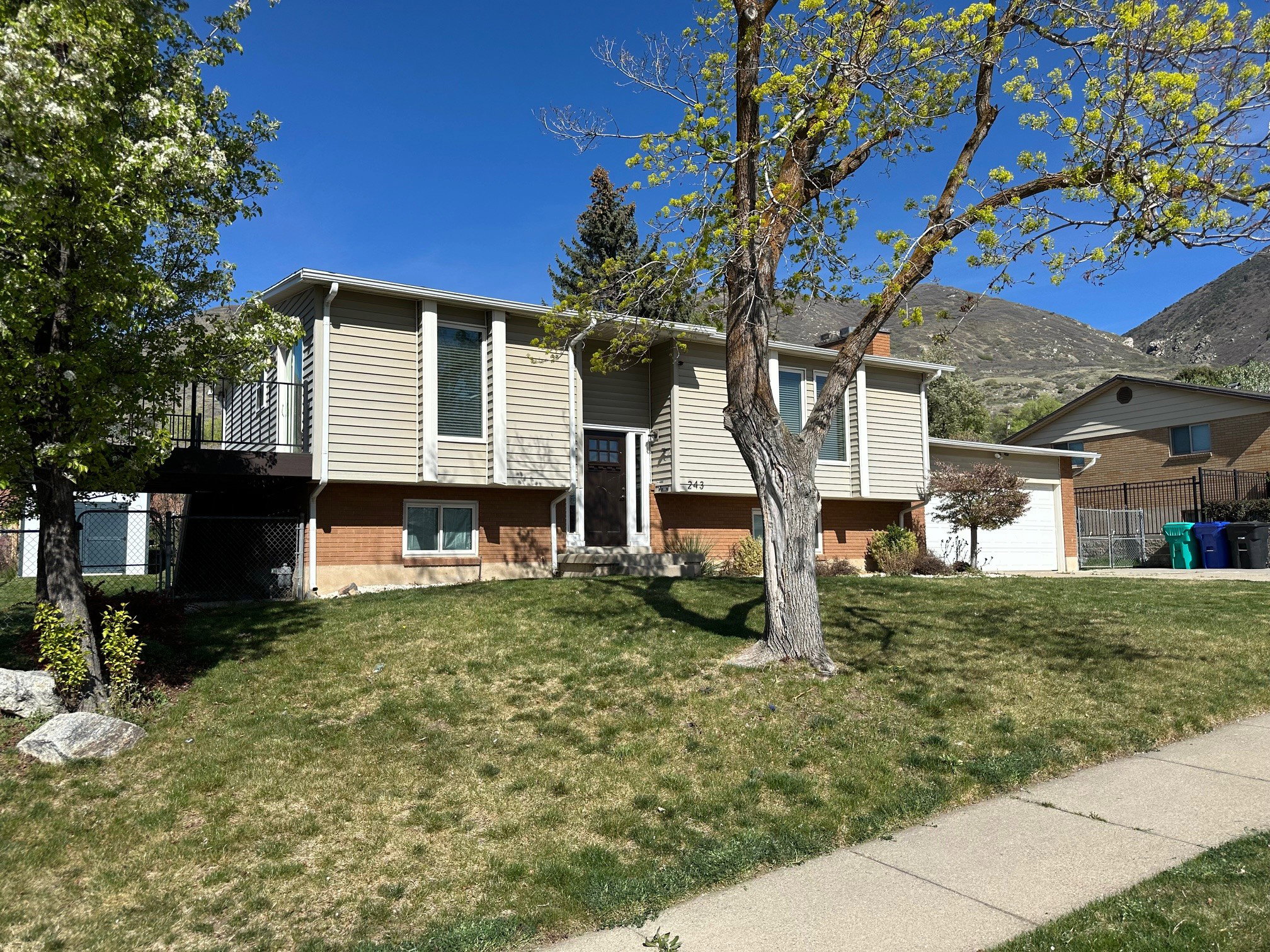 Raised ranch featuring a garage and brick siding