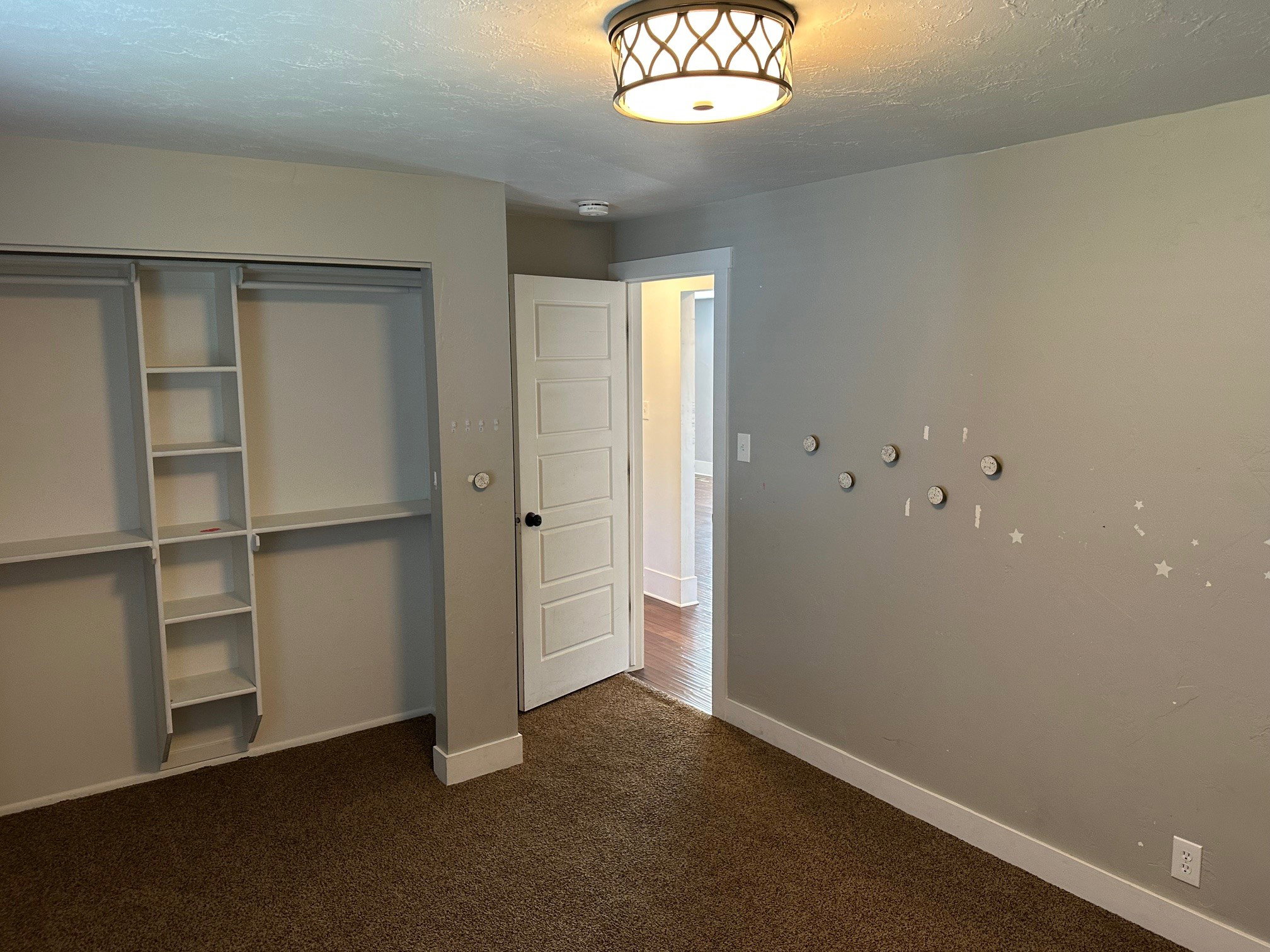 Unfurnished bedroom with dark carpet, a closet, and a textured ceiling