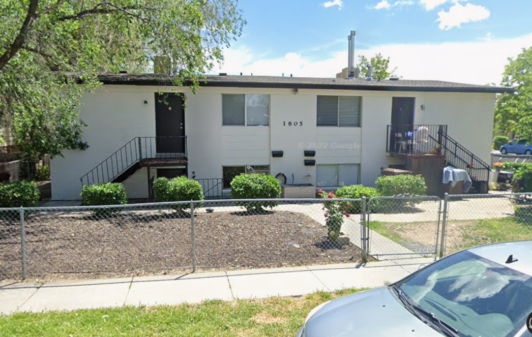 View of front of home featuring stucco siding, a fenced front yard, and a gate