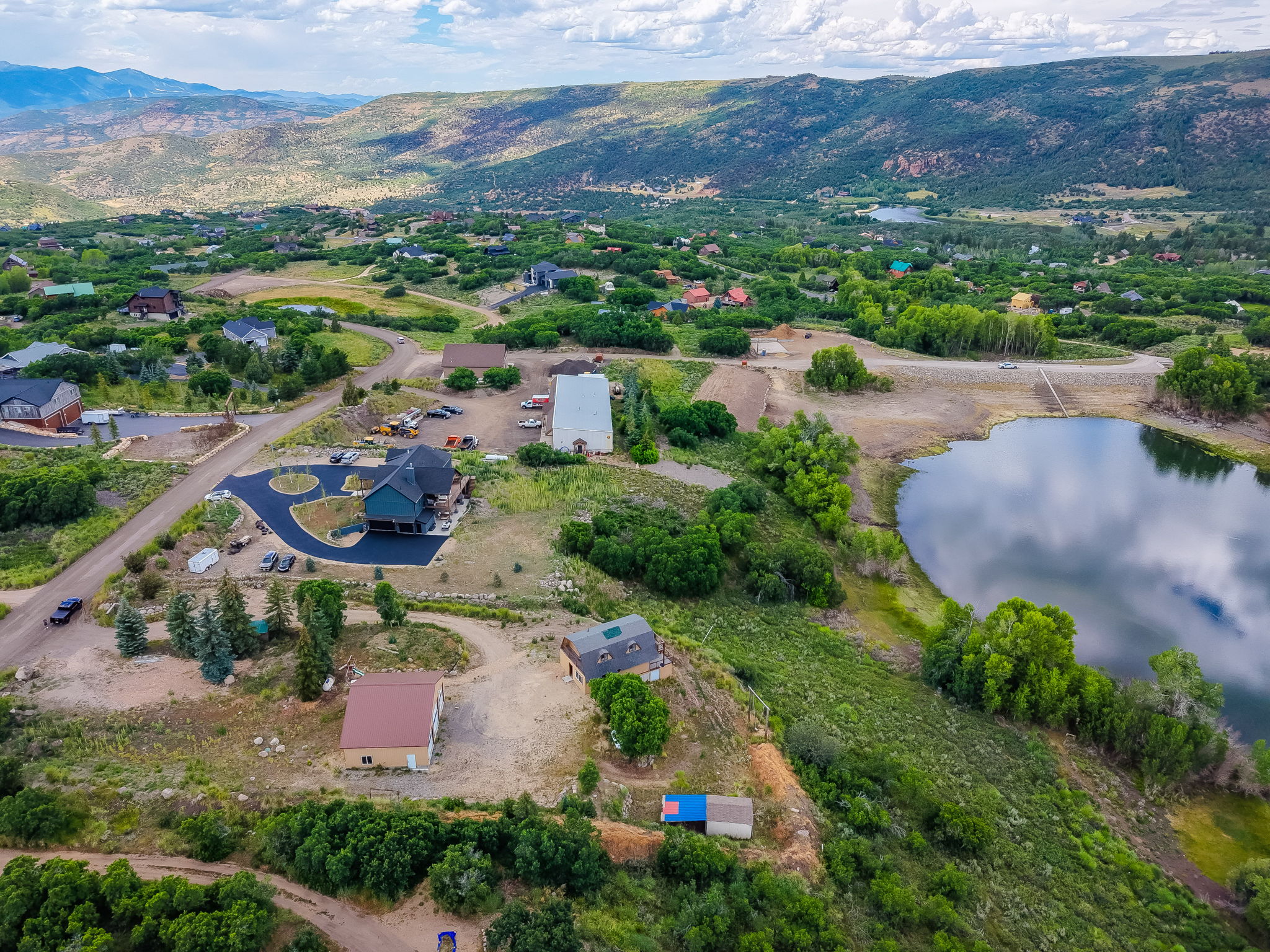 Aerial perspective showcasing a property with a paved driveway and landscaped grounds