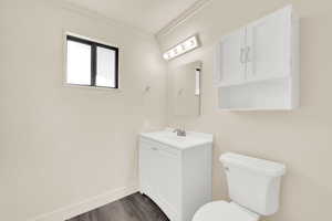 Bathroom with vanity, dark wood finished floors, and ornamental molding