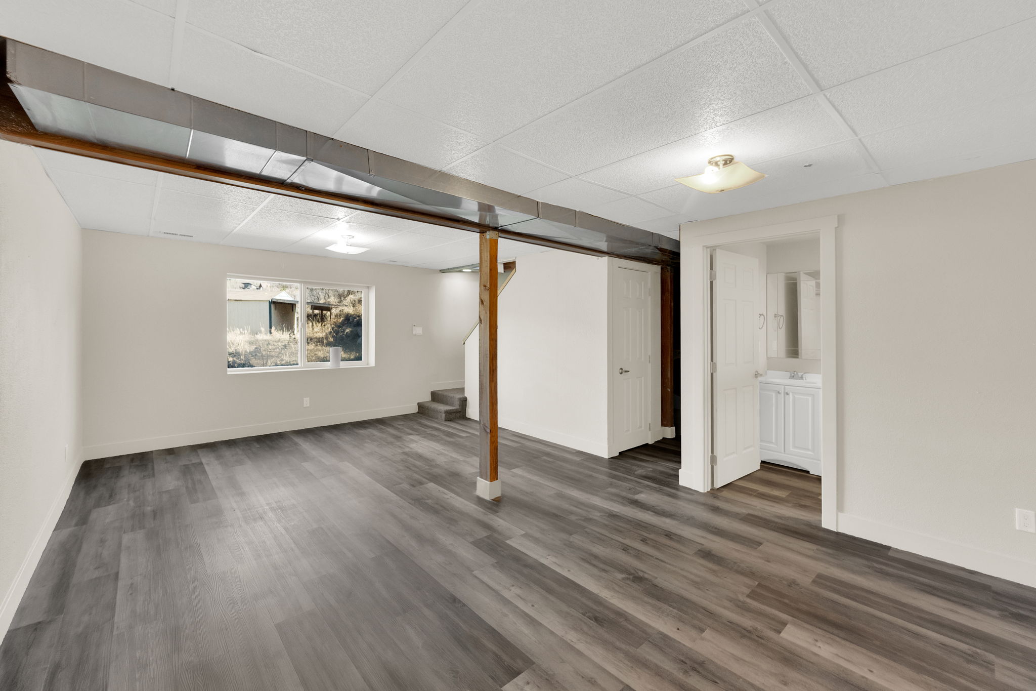 Basement with a paneled ceiling and dark wood-type flooring