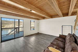 Living area with wood finished floors and a wooden ceiling with exposed beams