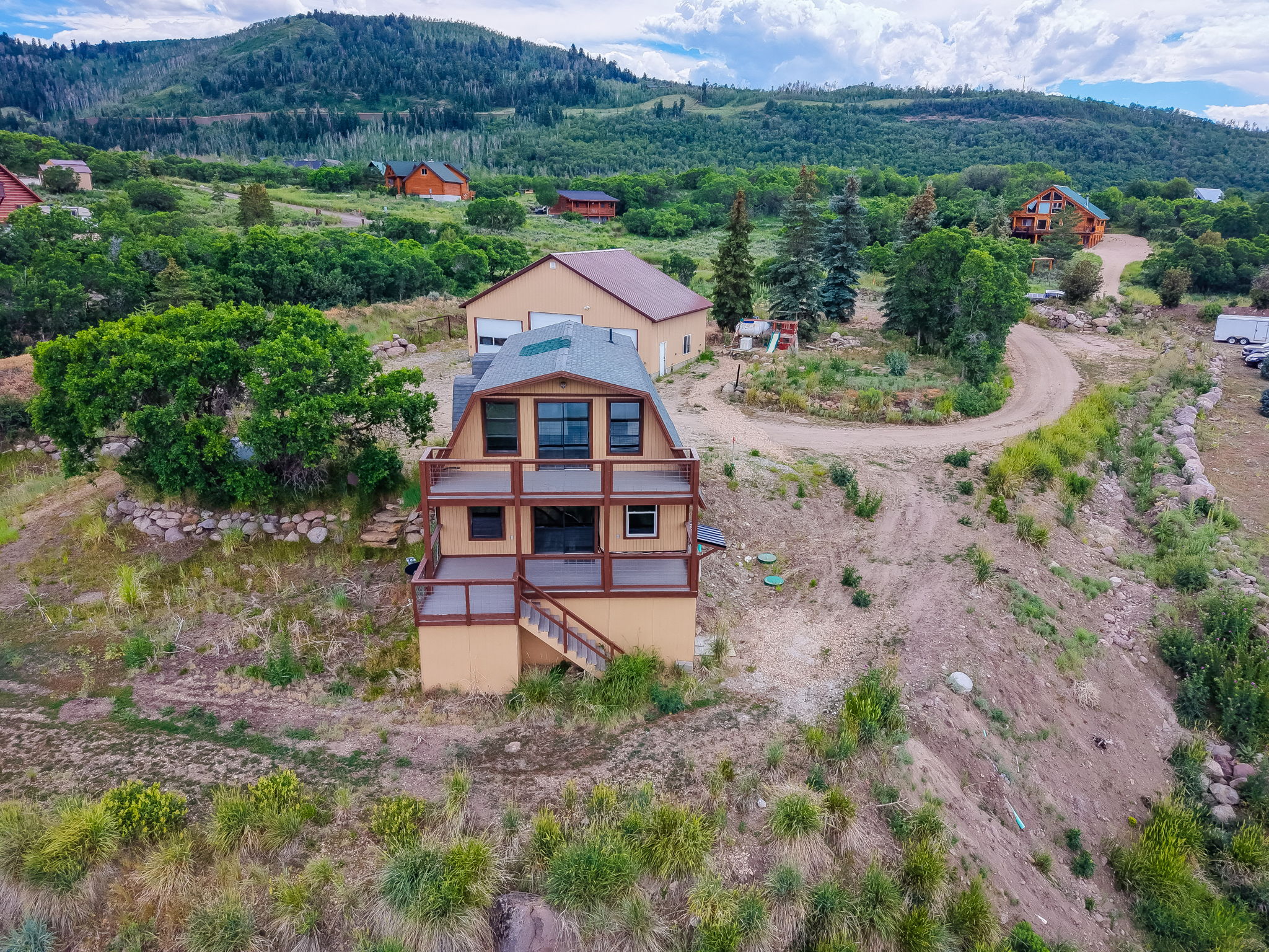 Multi-level residence featuring extensive outdoor decking, multiple balconies, and an adjacent detached structure