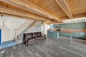 Living room with a wooden ceiling with exposed beams and light wood-style flooring