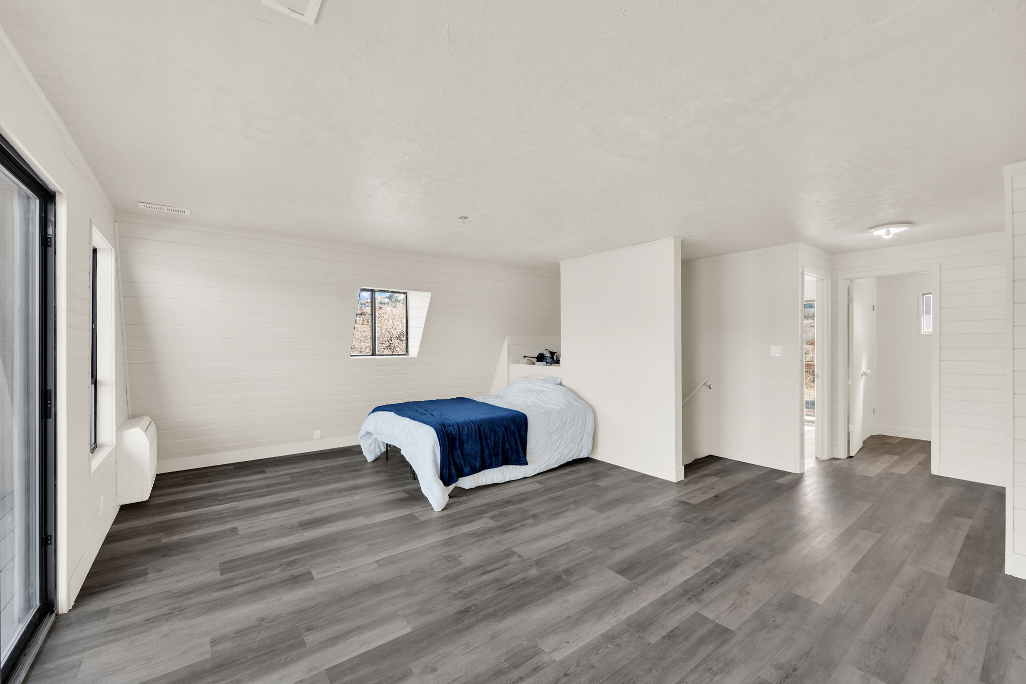 Unfurnished bedroom featuring dark wood-style flooring and wooden walls