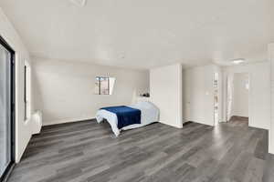 Unfurnished bedroom featuring dark wood-style flooring and wooden walls
