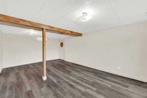 Finished below grade area featuring dark wood-style floors and a paneled ceiling