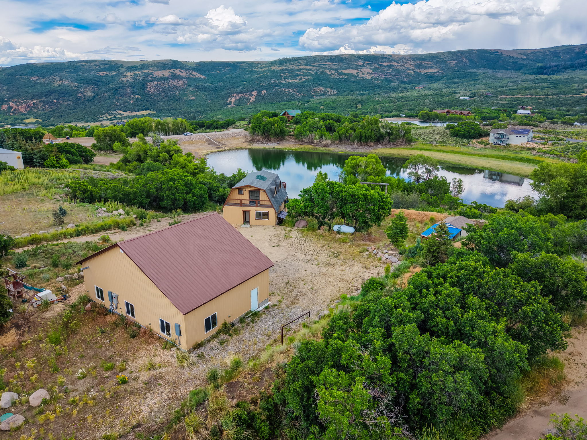 Two structures on a large parcel with a substantial body of water and distant mountains