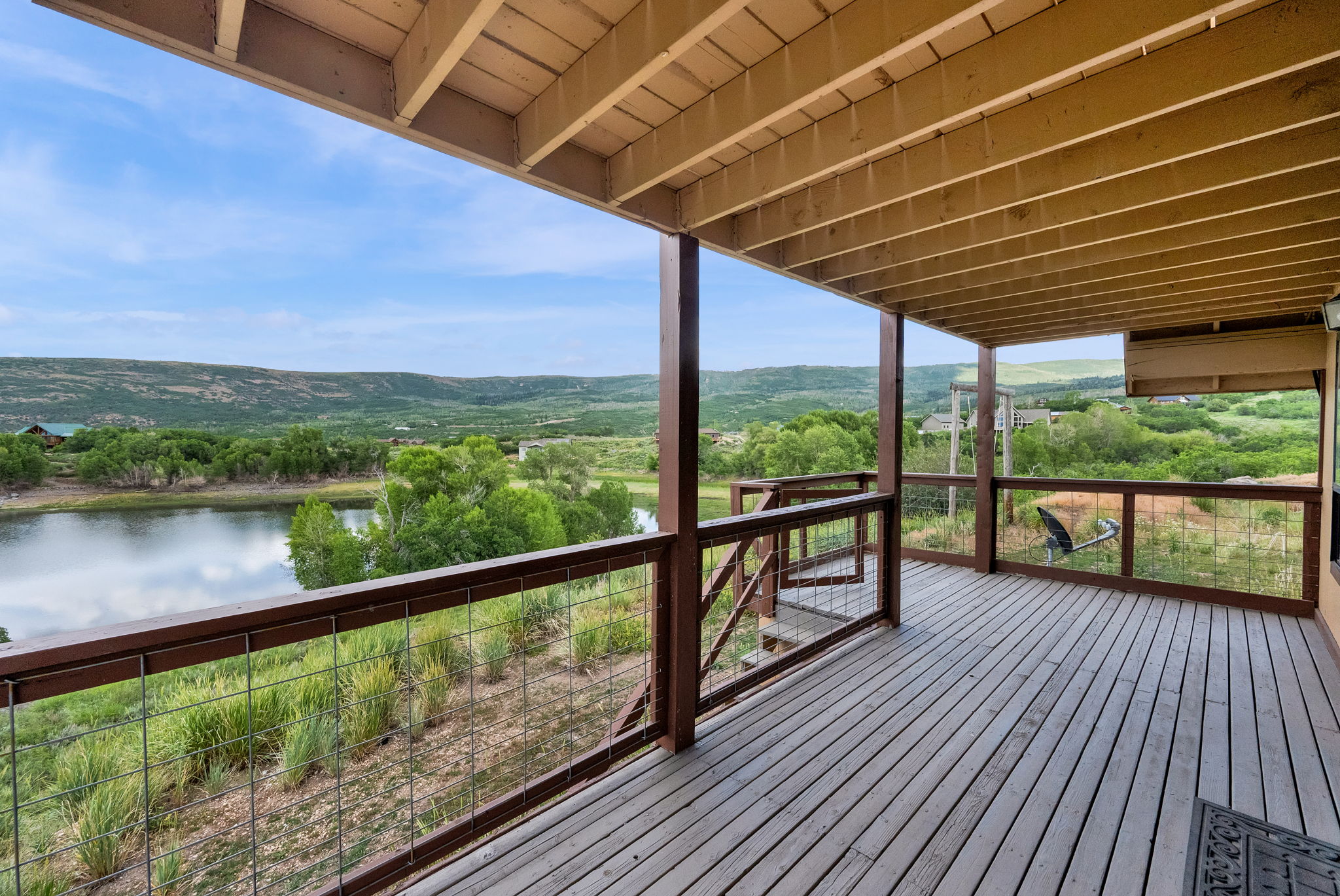 Expansive wood deck with a slatted floor and open ceiling beams