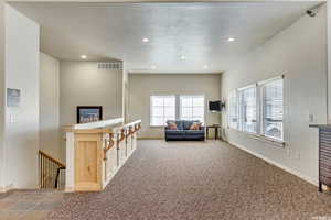 Carpeted living area featuring recessed lighting and baseboards
