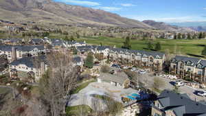 Aerial perspective of suburban area featuring a mountain backdrop and a local golf course