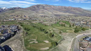 Aerial perspective of suburban area with a mountainous background and a golf club
