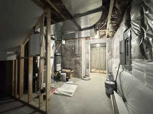 Unfinished below grade area featuring electric panel and gas water heater