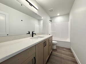 Full bathroom featuring vanity, shower / bathtub combination, and dark wood finished floors