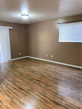 Spare room with a textured ceiling and dark wood finished floors