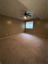 Carpeted spare room featuring ceiling fan and a textured ceiling