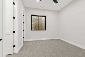 Empty room with light colored carpet and ceiling fan