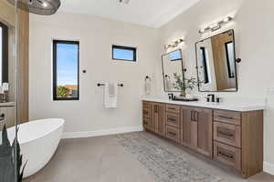 Full bath with double vanity and a freestanding tub