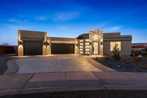 Contemporary home with an attached garage, stone siding, concrete driveway, and stucco siding