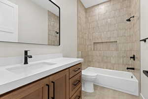 Bathroom with vanity, shower / tub combination, and light tile patterned flooring