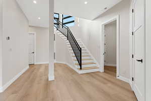 Stairs featuring wood finished floors and recessed lighting