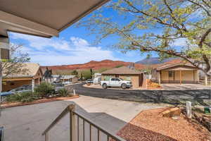 View of concrete driveway with a mountain view and a residential view