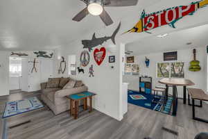 Living area featuring vaulted ceiling, a ceiling fan, and dark wood finished floors