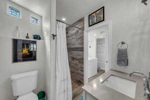 Full bath with vanity, a stall shower, and washer / clothes dryer