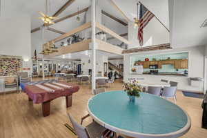 Dining room featuring a ceiling fan, billiards, light wood-type flooring, and lofted ceiling
