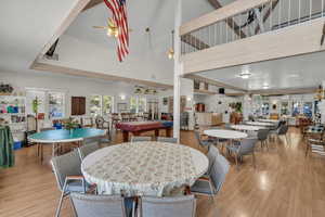 Dining area with pool table, wood finished floors, ceiling fan, plenty of natural light, and a high ceiling