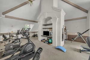 Workout area featuring lofted ceiling and ornate columns